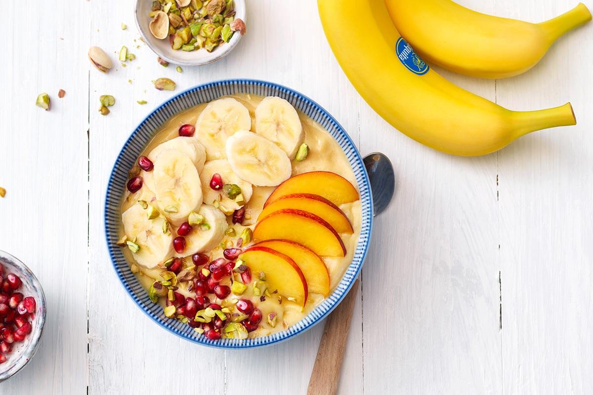 Smoothie bowl With banana, nectarines and pomegranate seeds